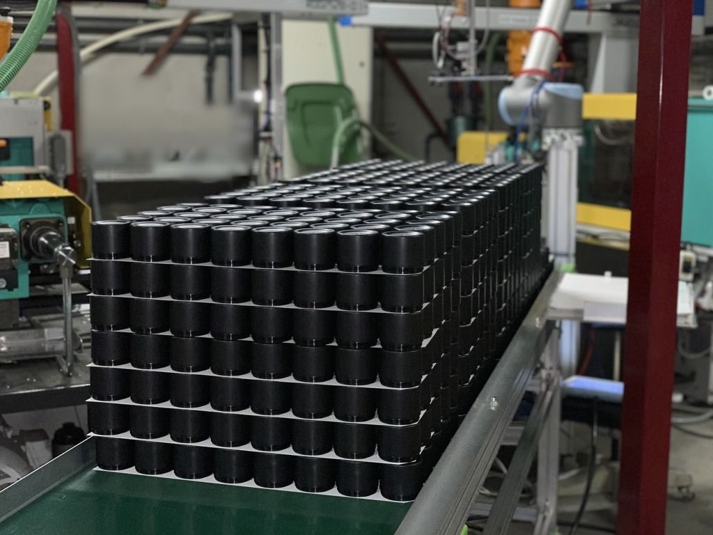 Zwarte potten op de afvoerband bij de spuitgietmachines in Wichelen